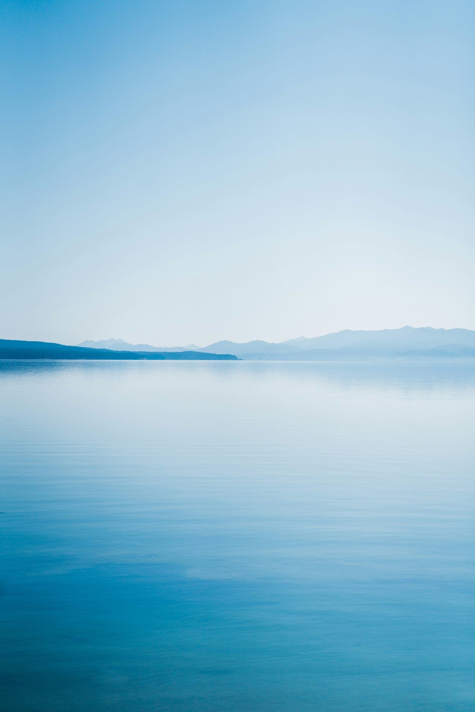 blue body of water under white sky during daytime